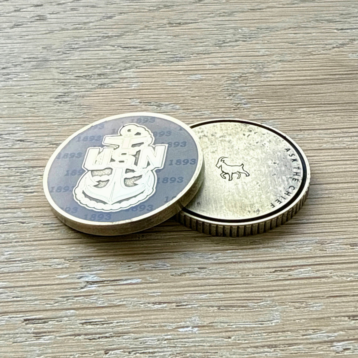 USN anchor golf ball marker showing the anchor design on the front and engraved Swell Marks goat logo on the back