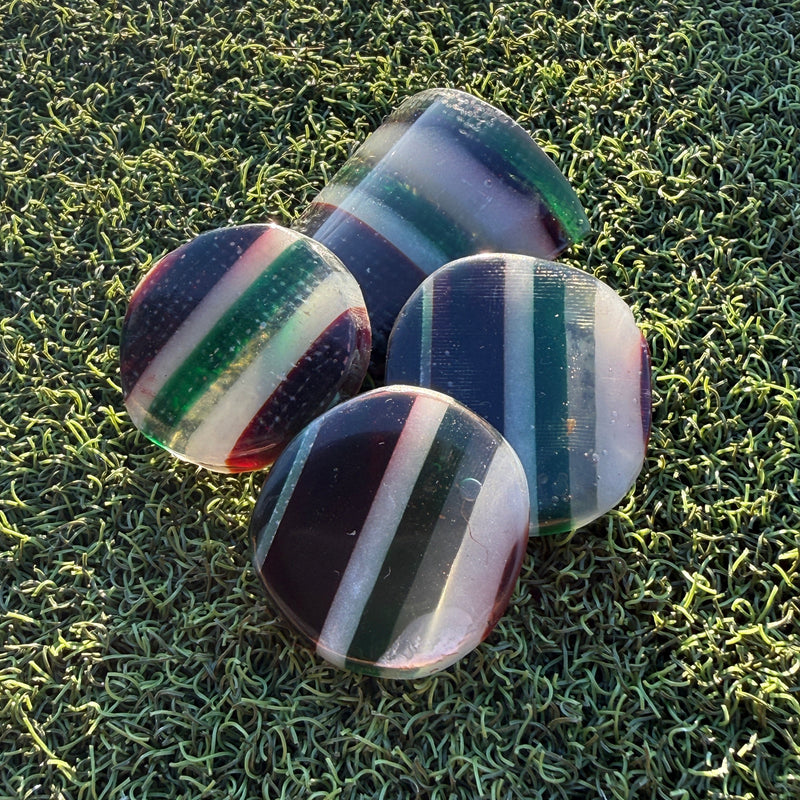 Swell Marks Leftovers handmade resin golf ball markers cut from layered leftover resin and fiberglass.